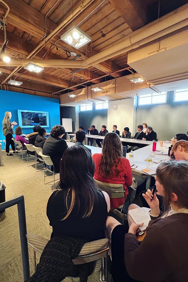 Several CAPS students in a board room listening to a presentation