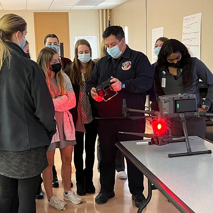 CAPS students being presented new electronic equipment in a classroom